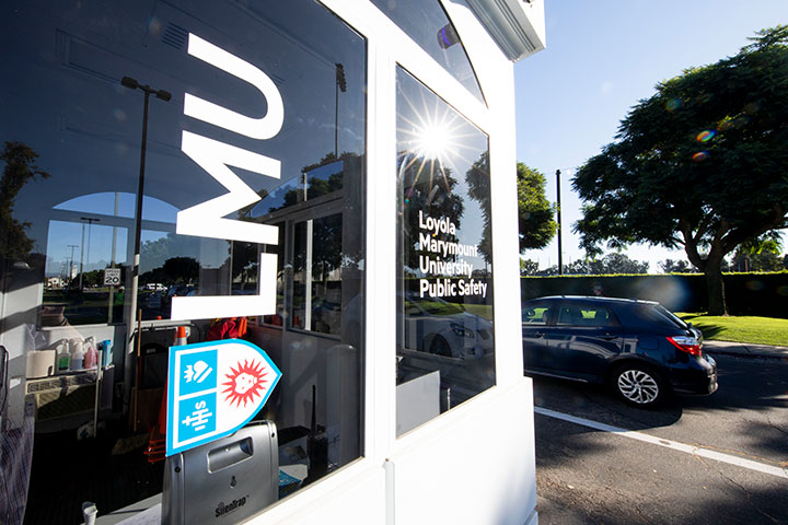 The Campus Safety guard shack at the Loyola Blvd entrance with an LMU logo on its window