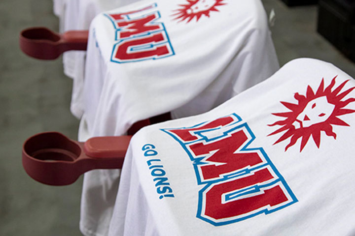 LMU branded shirts with the words Go Lions laid over chairs at an athletics event