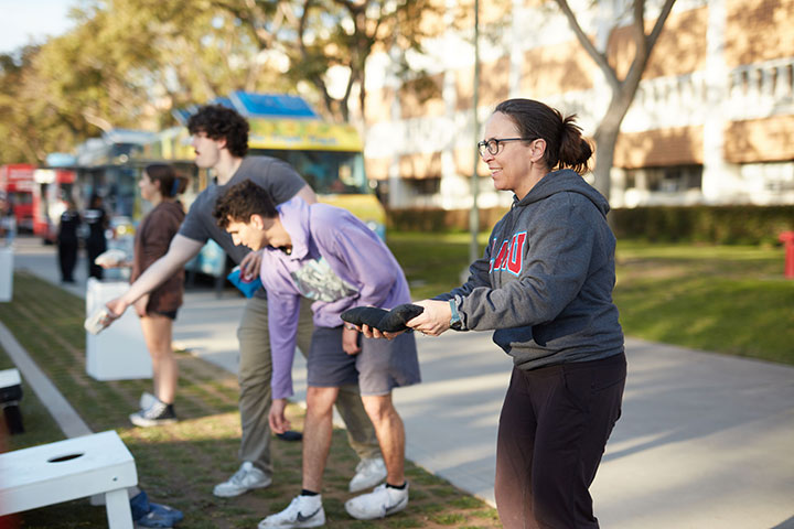Several LMU students and family members playing corn hole